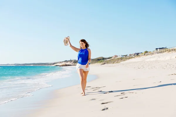 Junge Frau läuft am Strand entlang — Stockfoto