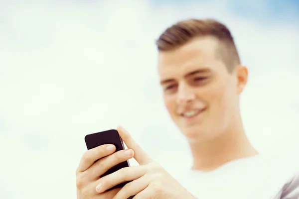Male runner with his mobile smart phone standing outdoors — Stock Photo, Image