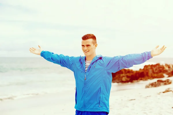 Young man in sport wear with outstretched arms — Stock Photo, Image