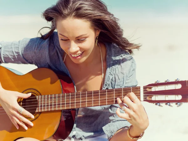 Piękna młoda kobieta gra na gitarze na plaży — Zdjęcie stockowe