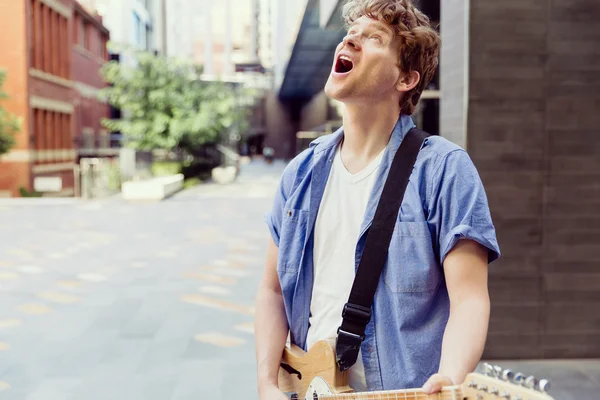 Young musician with guitar in city — Stock Photo, Image