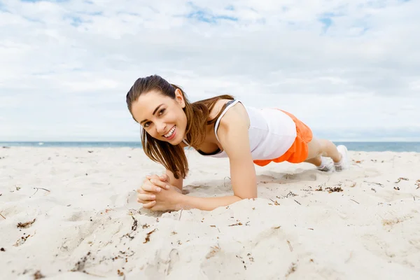 Mujer joven entrenando en la playa afuera —  Fotos de Stock