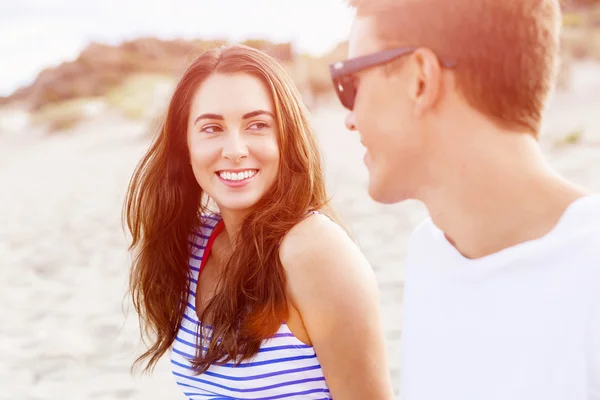 Romantiska unga paret sitter på stranden — Stockfoto