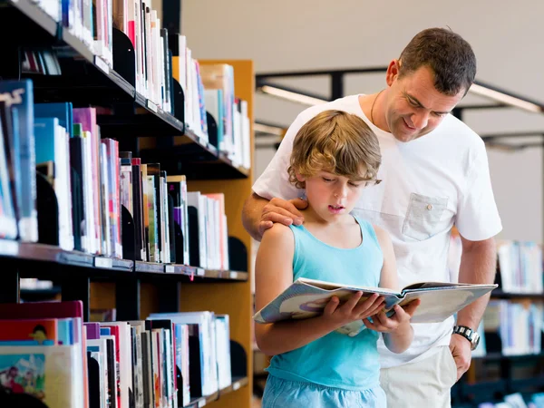 Pojke och hans far i biblioteket — Stockfoto