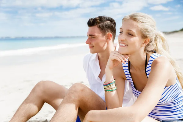 Romantisches junges Paar sitzt am Strand — Stockfoto