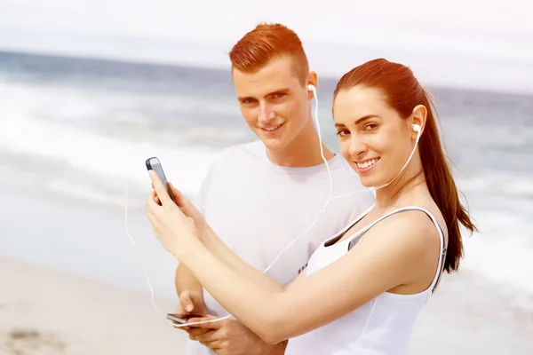 Läuferpaar mit Handy im Freien — Stockfoto