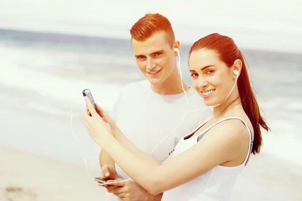 Casal de corredores com telefones inteligentes móveis ao ar livre — Fotografia de Stock