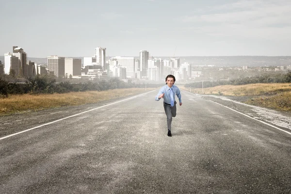 Бизнесмен бегает по дороге — стоковое фото
