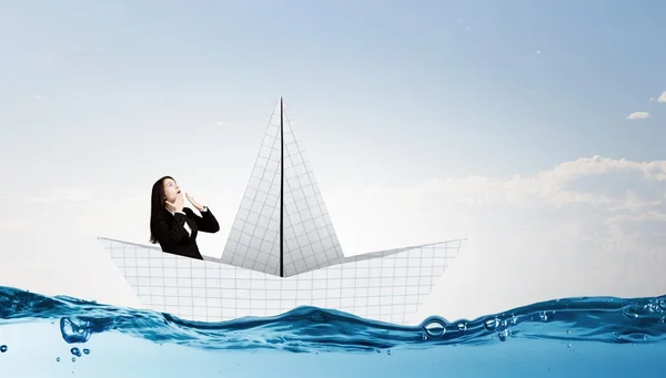 Businesswoman in boat made of paper — Stock Photo, Image