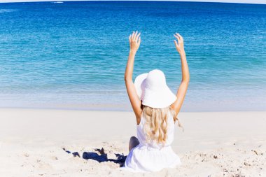 Genç bir kadın sahilde dinleniyor.