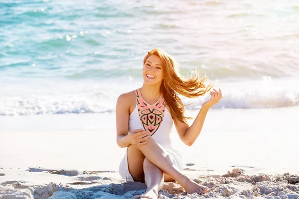 Молода жінка сидить на пляжі — стокове фото