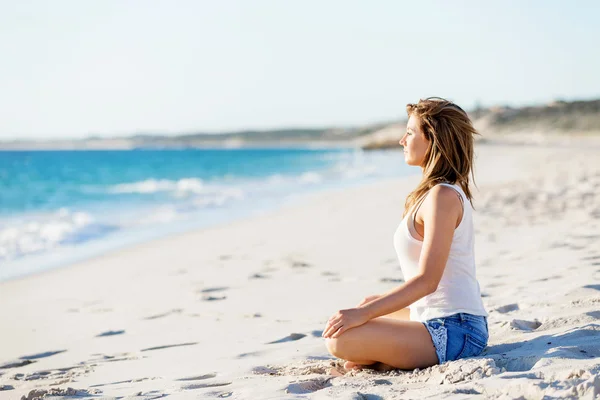 Mujer joven relajándose en la playa — Foto de Stock