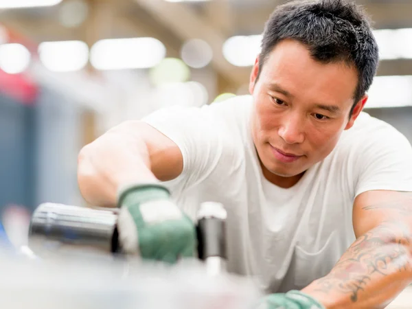 Asian worker in production plant on the factory floor — Stock Photo, Image