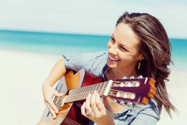 Piękna młoda kobieta gra na gitarze na plaży — Zdjęcie stockowe