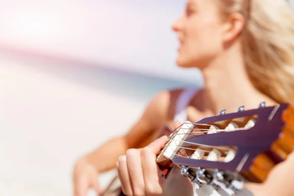 Bella giovane donna che suona la chitarra sulla spiaggia — Foto Stock