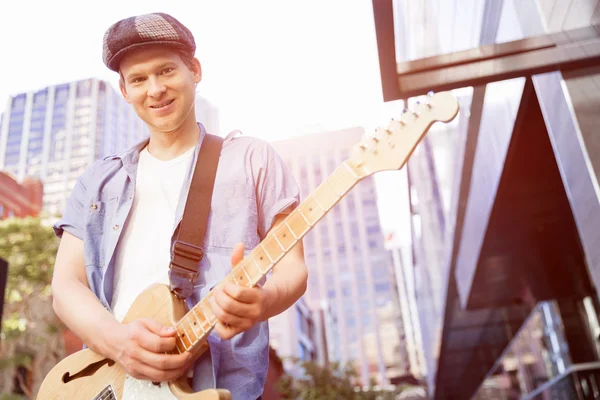 Young musician with guitar in city — Stock Photo, Image