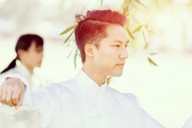 Yakışıklı adam Thai Chi yapıyor.