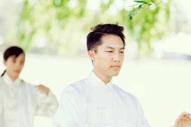 Yakışıklı adam Thai Chi yapıyor.