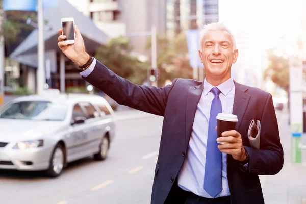 Empresario cogiendo un taxi en la ciudad — Foto de Stock