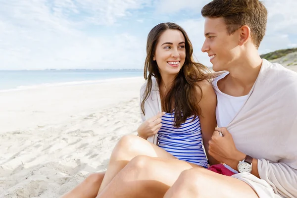 Romántica pareja joven sentada en la playa —  Fotos de Stock