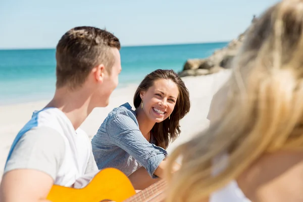Красивые молодые люди с гитарой на пляже — стоковое фото