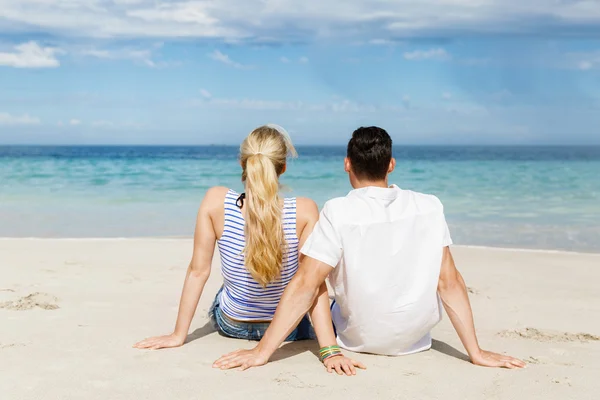 Romântico jovem casal sentado na praia — Fotografia de Stock