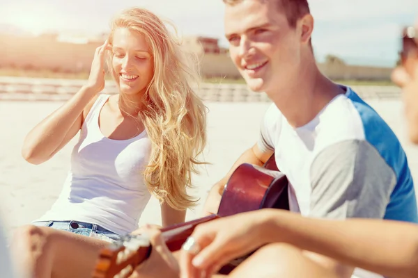 Hermosos jóvenes con guitarra en la playa —  Fotos de Stock