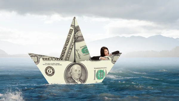 Бізнес-леді в човні з банкноти долара — стокове фото