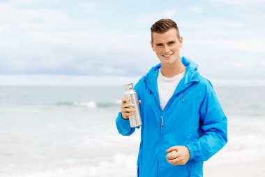 Şişe su ile tutarak kendine güvenen genç adam