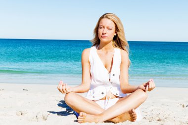 Genç bir kadın sahilde dinleniyor.