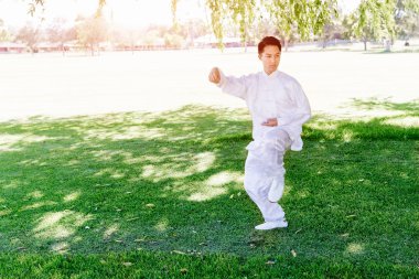 Yakışıklı adam Thai Chi yapıyor.