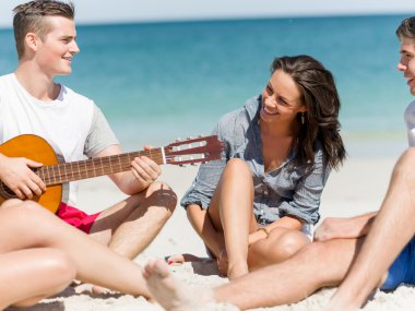 Sahilde gitar ile güzel gençler