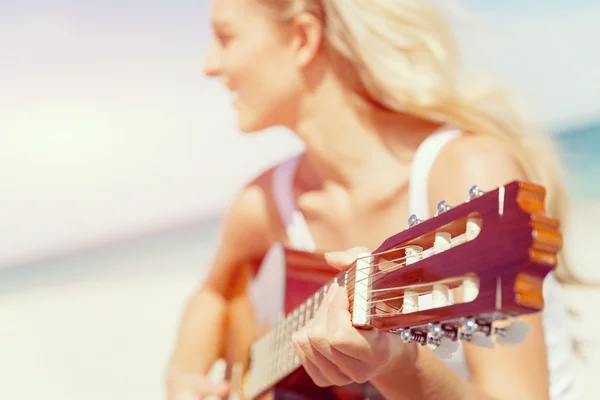 Belle jeune femme jouant de la guitare sur la plage — Photo