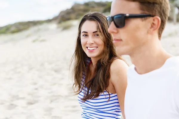 Romantiska unga paret sitter på stranden — Stockfoto