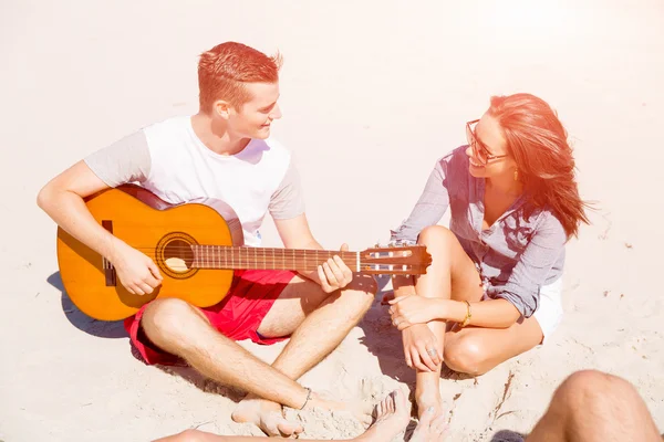 Hermosos jóvenes con guitarra en la playa —  Fotos de Stock