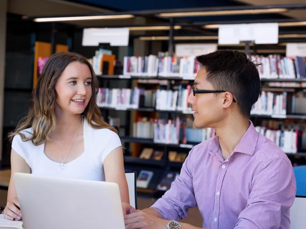 Dos jóvenes estudiantes en la biblioteca —  Fotos de Stock