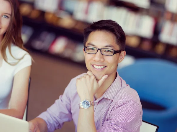 Feliz estudiante masculino trabajando en la biblioteca — Foto de Stock