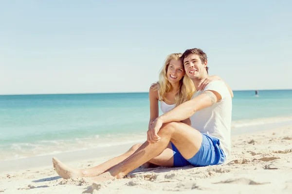 Romantique jeune couple assis sur la plage — Photo
