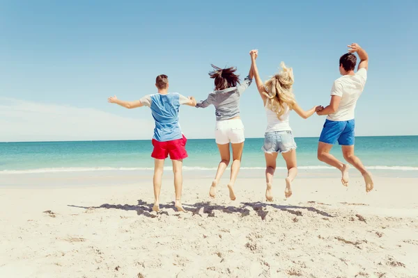 Gezelschap van jonge mensen op het strand — Stockfoto