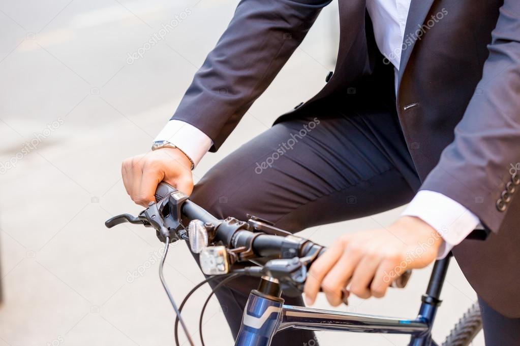 Successful businessman riding bicycle