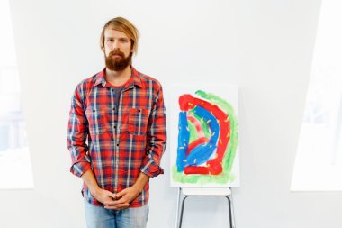 Bir resim ile ayakta genç erkek sanatçı