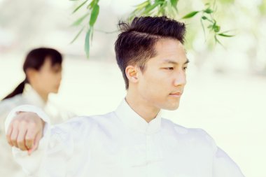 Yakışıklı adam Thai Chi yapıyor.