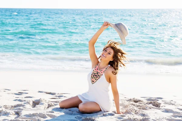 Jonge vrouw zittend op het strand — Stockfoto