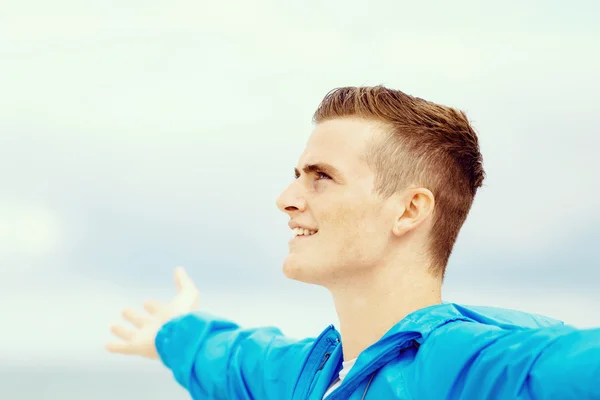 Young man in sport wear with outstretched arms — Stock Photo, Image