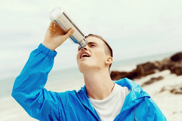 Чоловік п'є зі спортивної пляшки — стокове фото