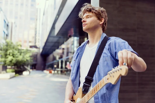 Joven músico con guitarra en la ciudad — Foto de Stock