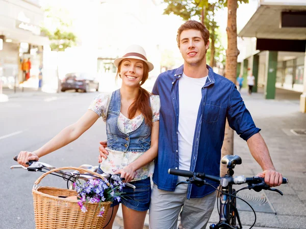 Pareja feliz en la ciudad con bicicleta —  Fotos de Stock