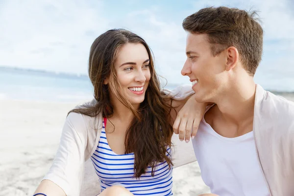 Romantyczna młoda para siedzi na plaży — Zdjęcie stockowe