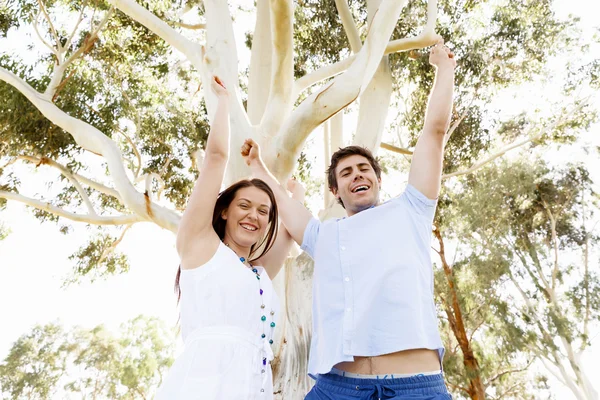 Pareja joven en el parque celebrando — Foto de Stock