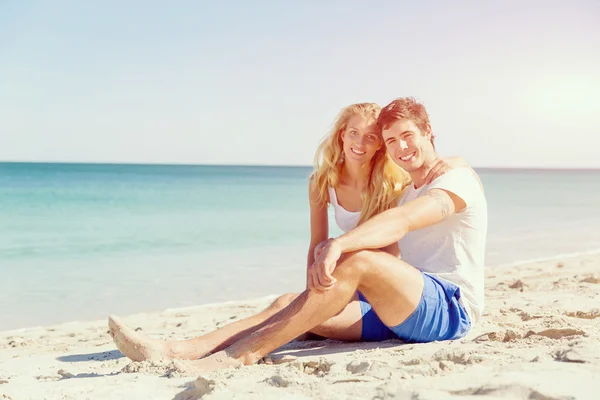해변에 앉아 로맨틱 젊은 부부 — 스톡 사진